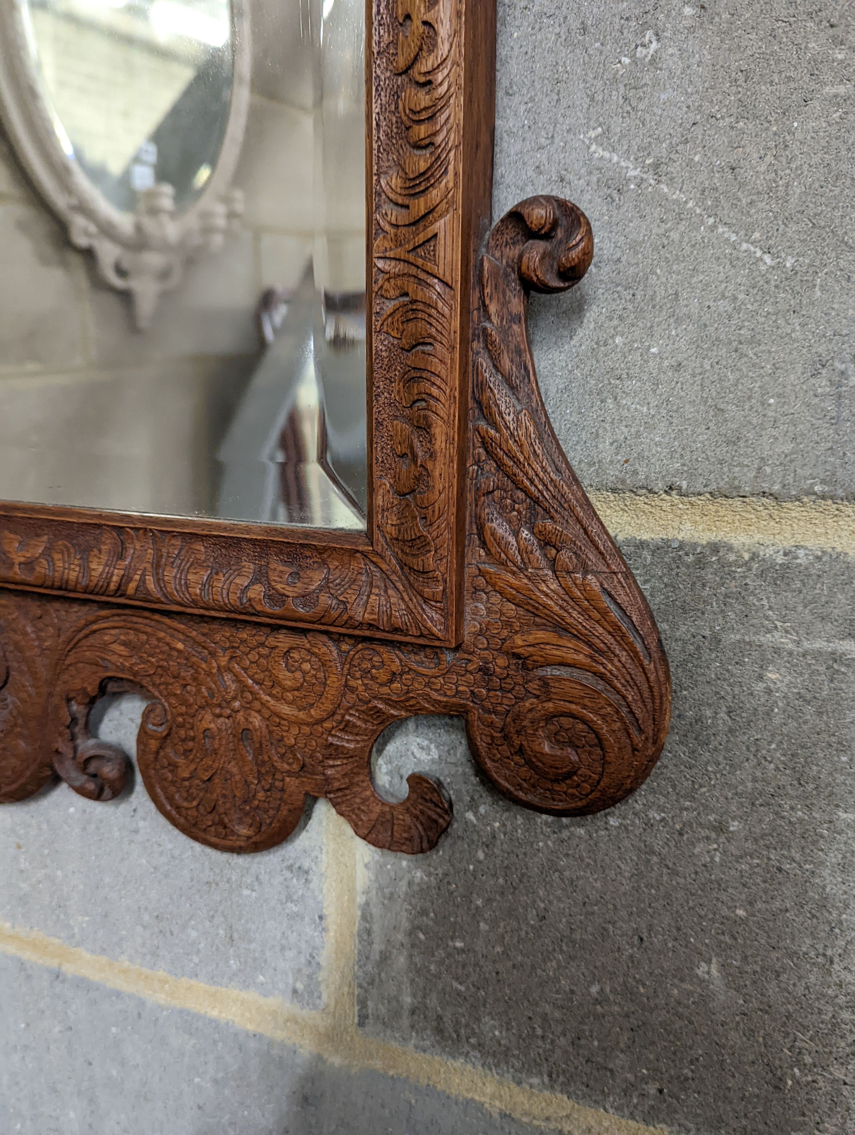 An 18th century style carved wood wall mirror, width 64cm, height 124cm
